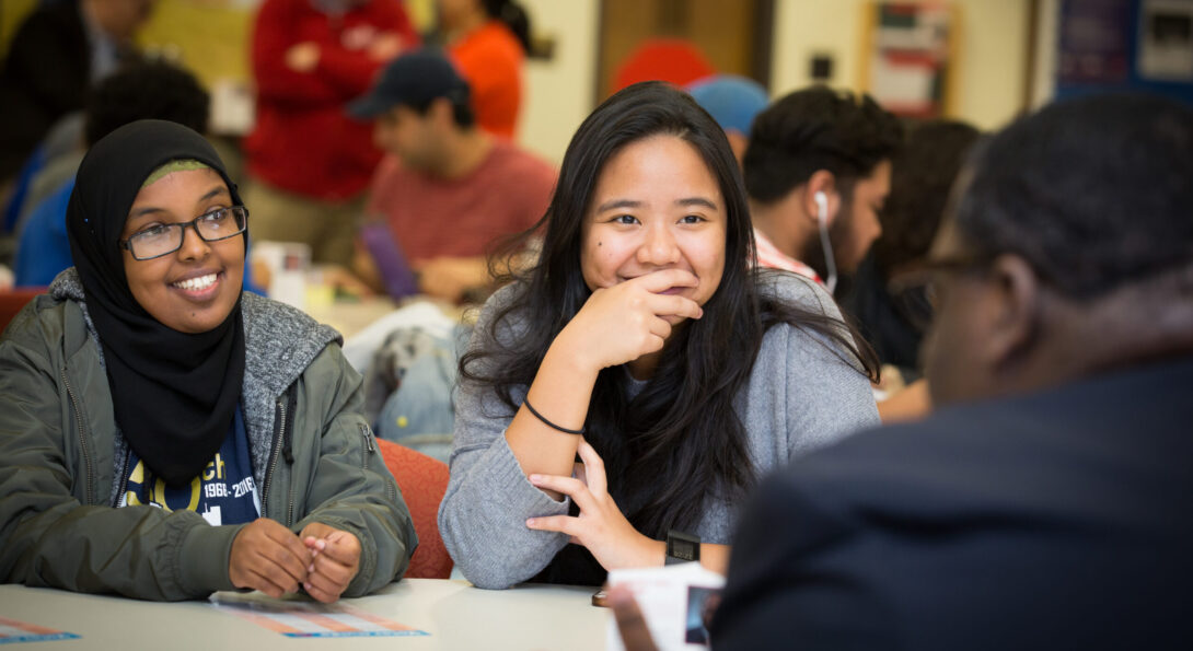Diverse students laughing together at table