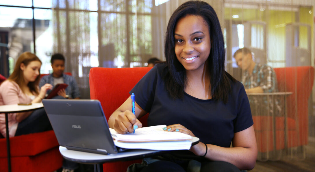 African American student with laptop and papers