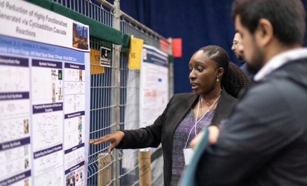 Female student presenting research at poster session