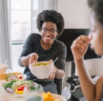 Two black women eating vegan food at home 