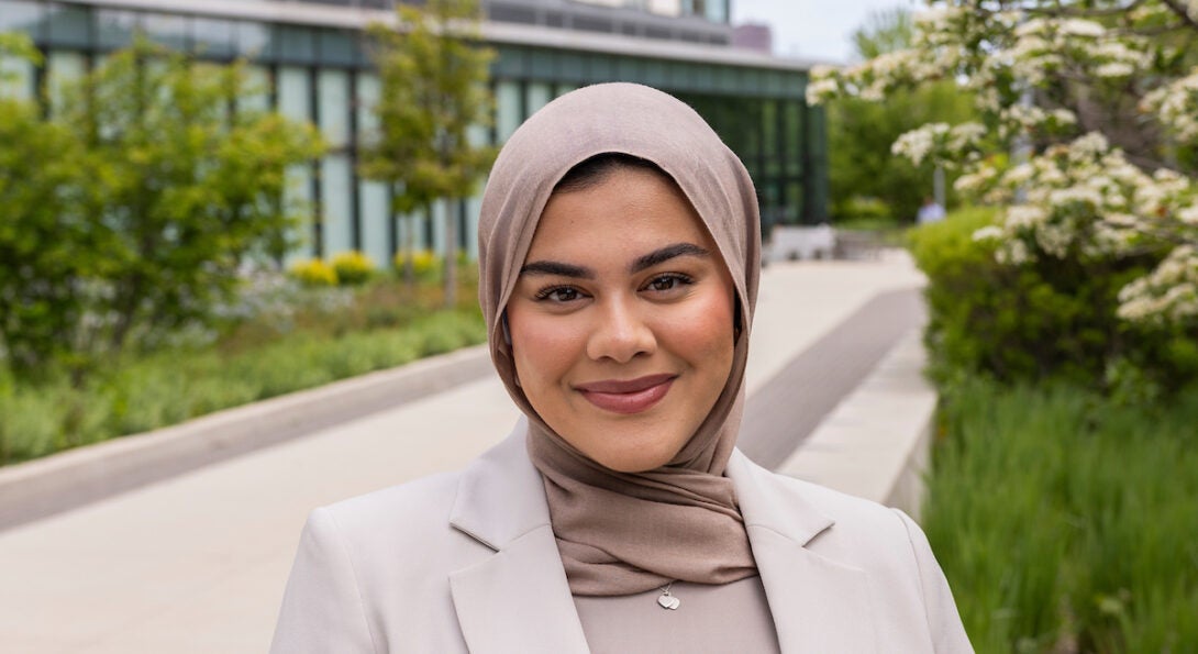 Young female student Nur stands in front of the Academic and Residential Complex on UIC's East Campus