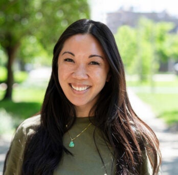 Loretta Hsueh smiling on the campus of the University of Illinois Chicago on a warm summer day in the sun.
                  