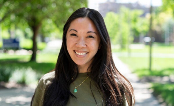 Loretta Hsueh smiling on the campus of the University of Illinois Chicago on a warm summer day in the sun.