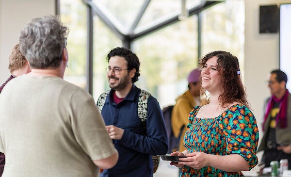 Two students socializing at an event at The Institute for the Humanities