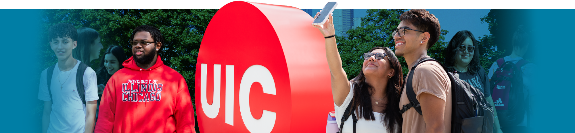 Students walking on campus in front of the UIC red doc logo on the first day of fall semester.