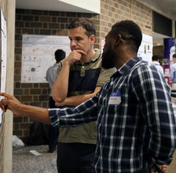 Jordi Cabana, professor of chemistry, discusses a poster with a student at the Next-Gen Electrochemistry workshop. (Photo: Jenny Fontaine/UIC) 