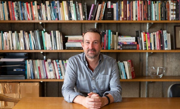 English Professor and Head of English Department Peter Coviello sits in front of his wall of books.