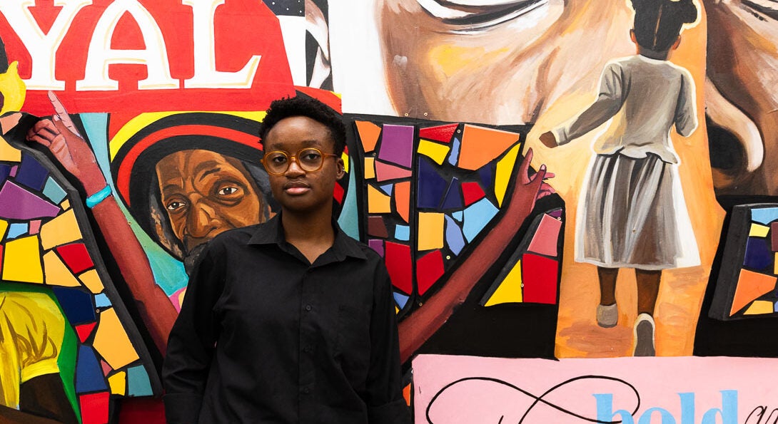 Venus Obazuaye stands in front of gallery wall at the Black Cultural Center