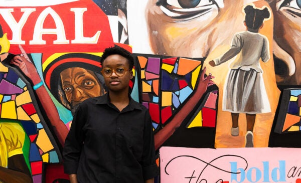 Venus Obazuaye stands in front of gallery wall at the Black Cultural Center