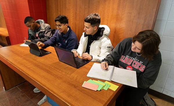 Students sitting at table on laptops