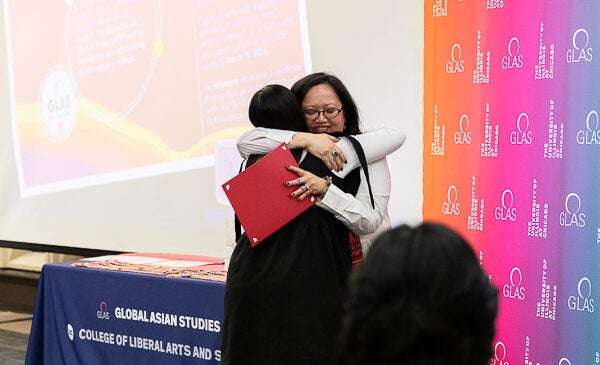 Professor hugs student at award ceremony