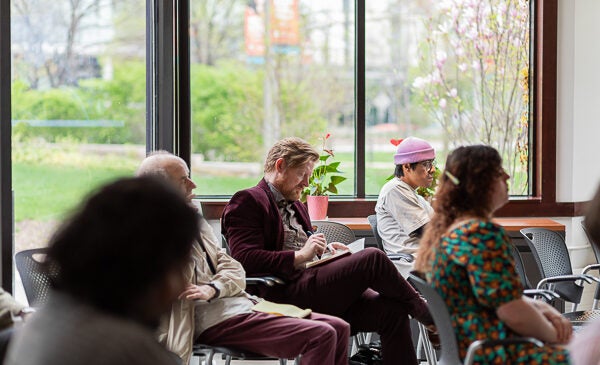 Event attendees sit taking notes at the Institute for the Humanities