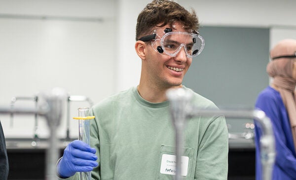 Student wearing goggles and holding science instrument