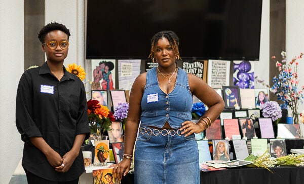 Two students stand in front of art project at the Black Cultural Center