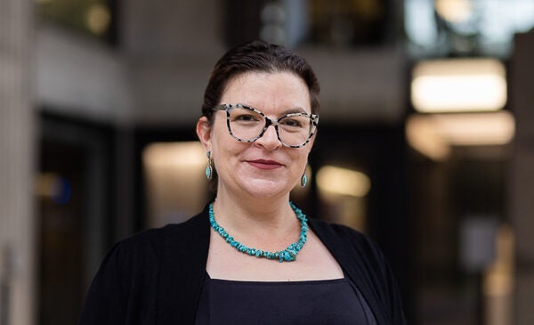 Pre-Health Advisor wearing blue necklace and glasses