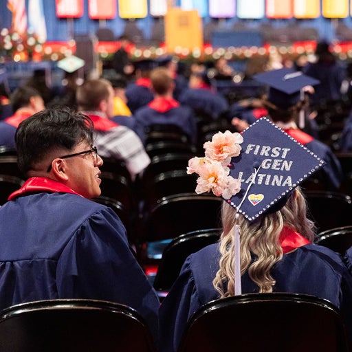 Students sitting at commencement wearing cap and gown