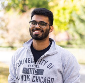 UIC Student Harshil Choudhary stands wearing gray sweatshirt on college campus
                  