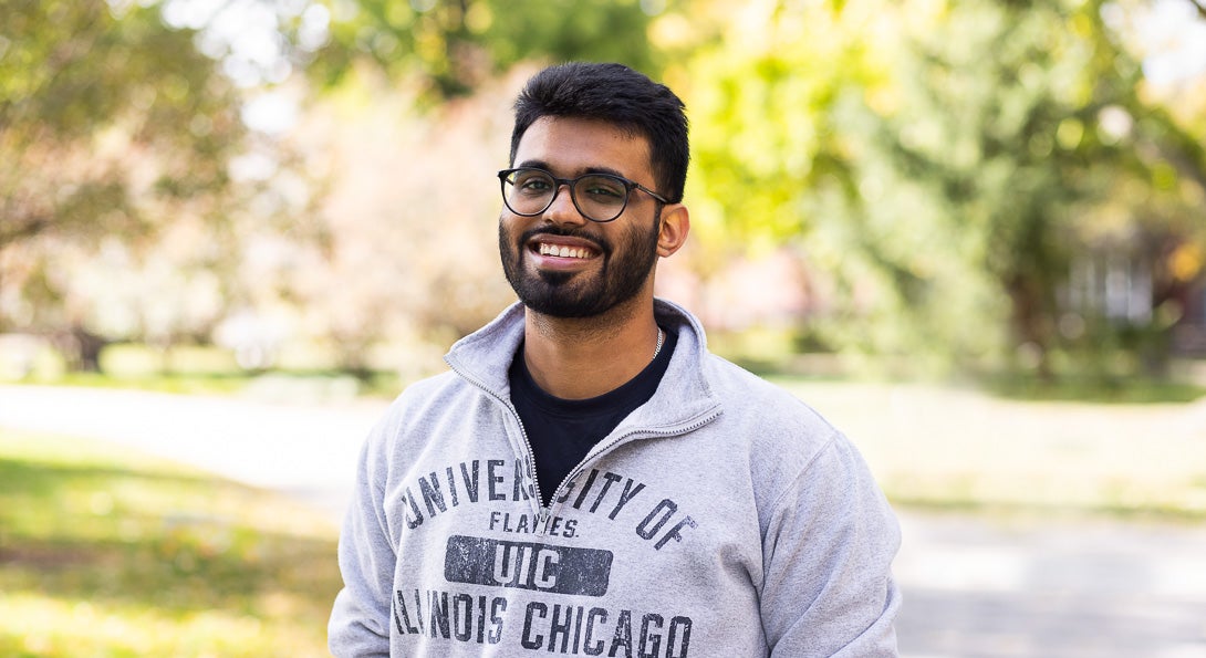 UIC Student Harshil Choudhary stands wearing gray sweatshirt on college campus