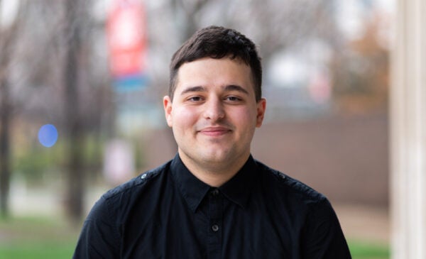 English student Liam Smith in black button down shirt on UIC's campus in the spring