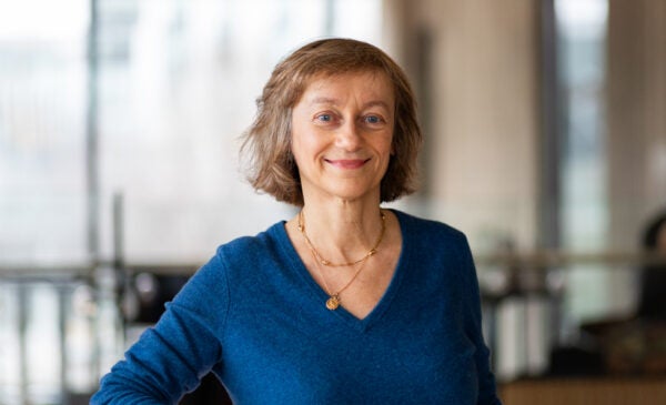 Professor Chiara Fabbian in blue sweater standing in Universitay Hall